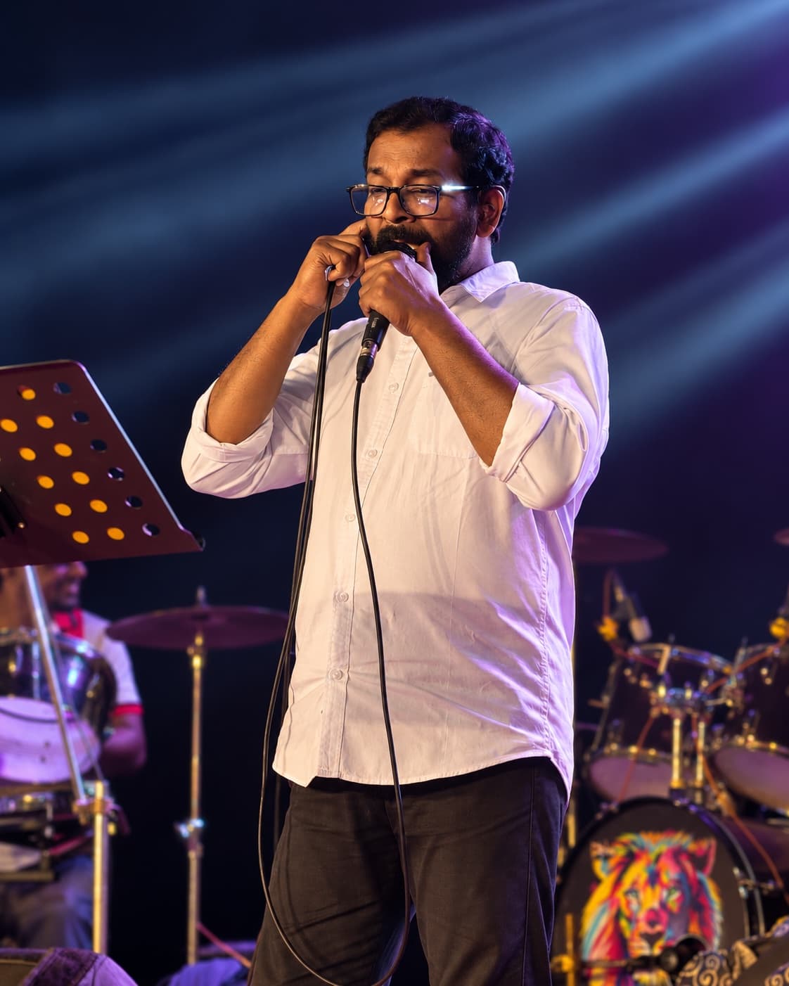 Prakash Sarang speaking into a microphone on stage